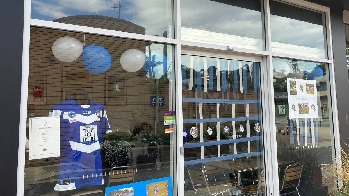 KJ's Cafe in Merimbula has posters made using photographs of some of the players, while jerseys hang in the windows. Picture by James Parker