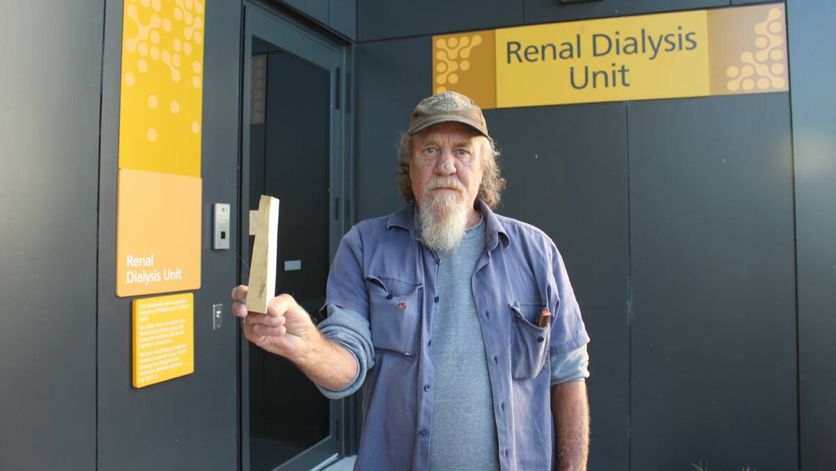 OPEN AND SHUT CASE: Wayne Longford with the wedge used to hold open the door to enable him to get wheelchairs in and out. Picture: Liz Tickner