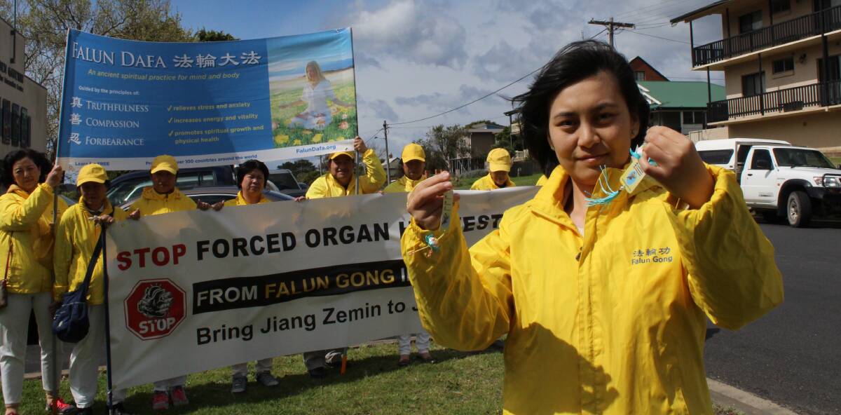 CAMPAIGN: Ni Yan, holding lotus flowers to give to supporters, was among a group of Falun Gong practitioners to visit Eden. Picture: Liz Tickner