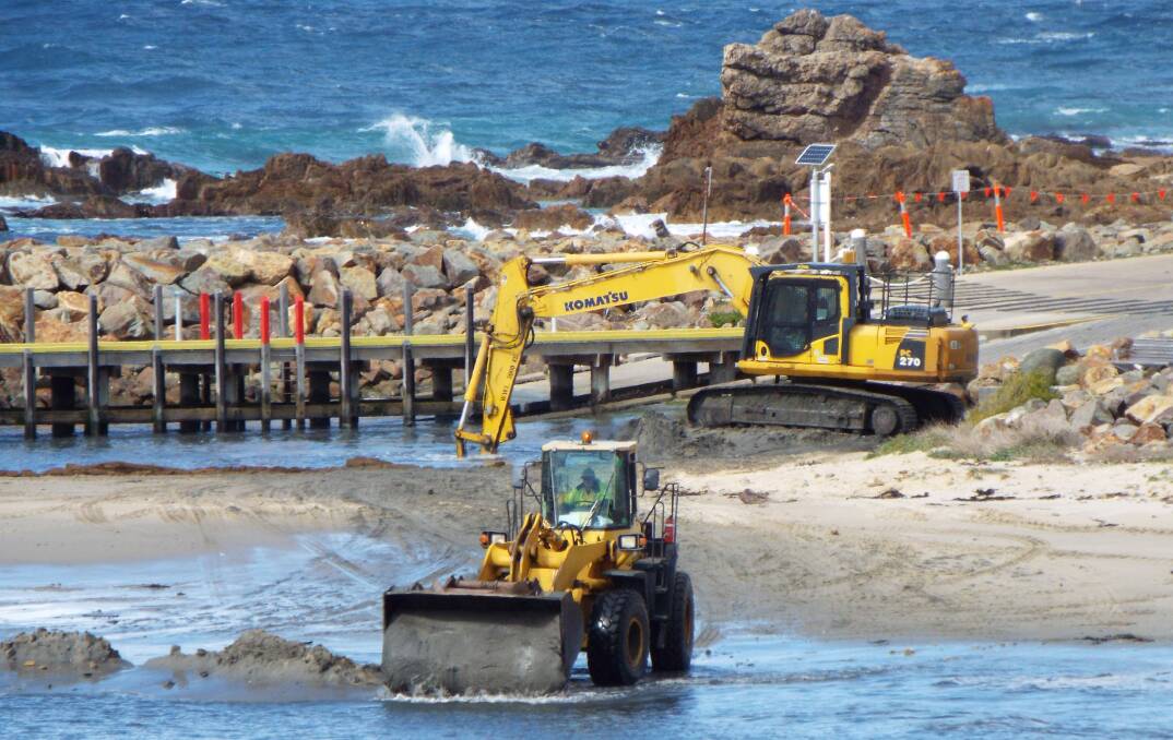 POINT OF CONTENTION: Work to clear the channel of sand continued at Mallacoota's ocean access boat ramp on Friday, August 18, sparking more claims of environmental damage and economic waste. 