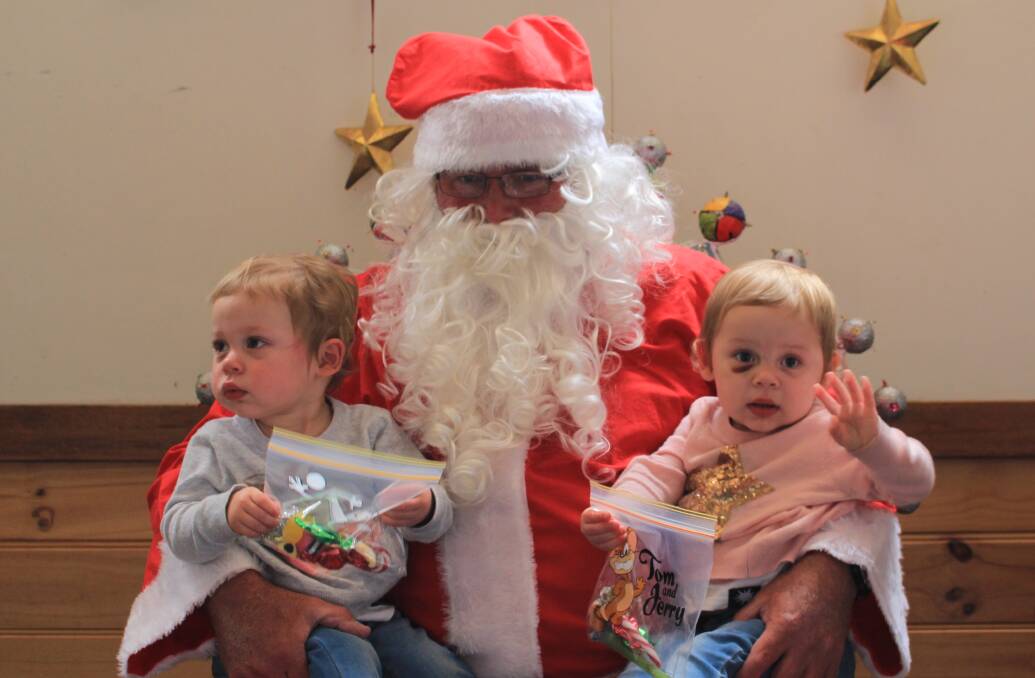 Double fun: TwinsIndi and Tahli Holding meet Santa at the Nethercote Christmas party on Saturday.
