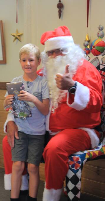 It's thumbs up from Santa as he hands out presents from his sack to happy local children.