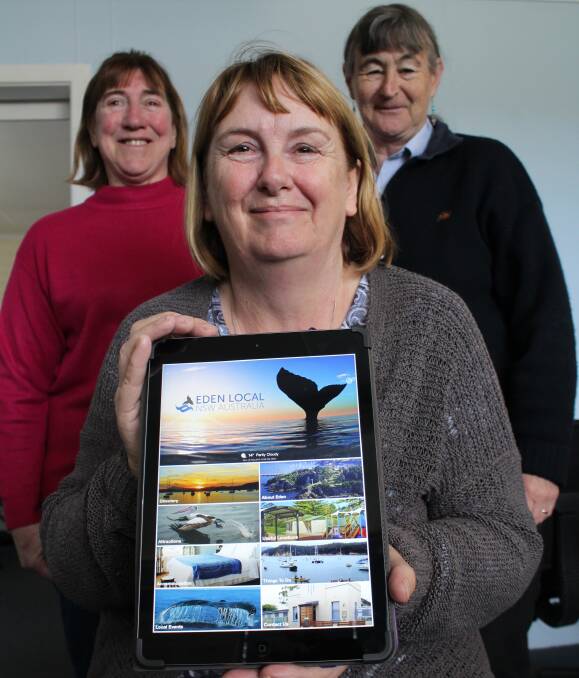 Eden Local App: Eden Community Access Centre project manager Vera Clark holds up an Ipad displaying the new App, with ECAC volunteers Maree O'Neill and Hellen Walder behind, Monday September 26. Picture: Toni Houston