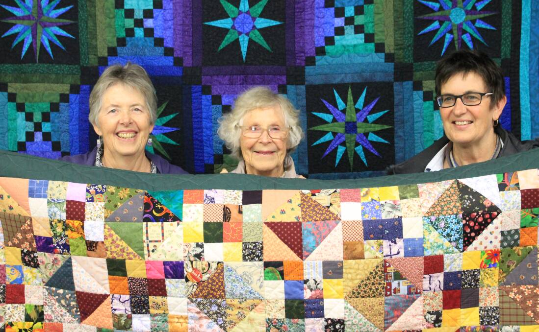 COLOURFUL CREATIONS: Eden Log Cabin quilters Leah McKinnon, Elaine Craker and Marlene Stubbs show off some of the quilts at their exhibition over the weekend. 