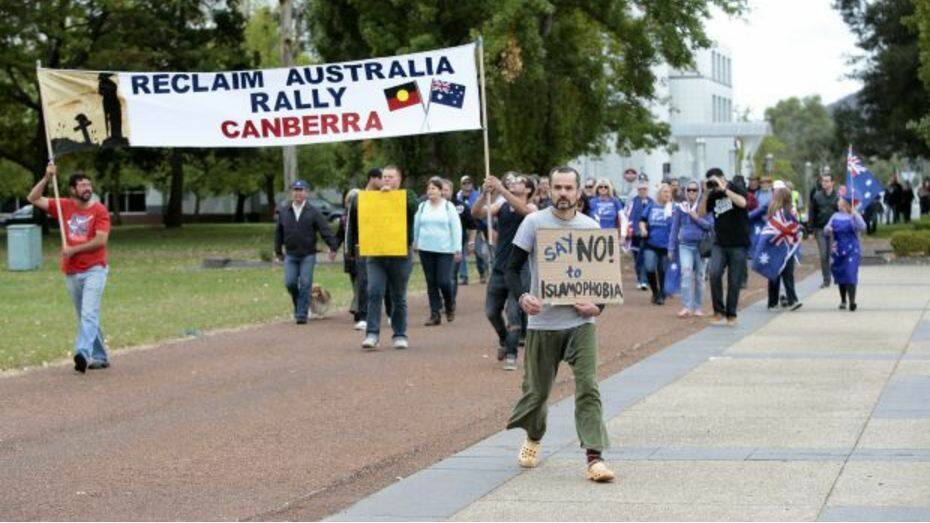 SAY NO: Protester Ben Keaney, centre, marches against supporters of Reclaim Australia in front of the National Library of Australia in April. Photo: Jeffrey Chan