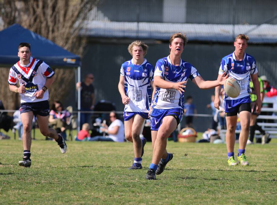 Give it: The Merimbula-Pambula Bulldogs send the ball down the line during a bruising grand final loss to the Bega Roosters on Sunday. 