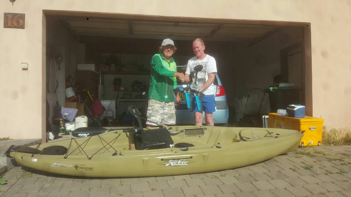Pambula Fishing Club president Joe Klimas congratulates Kobie kayak winner Paul McPherson on Thursday. 