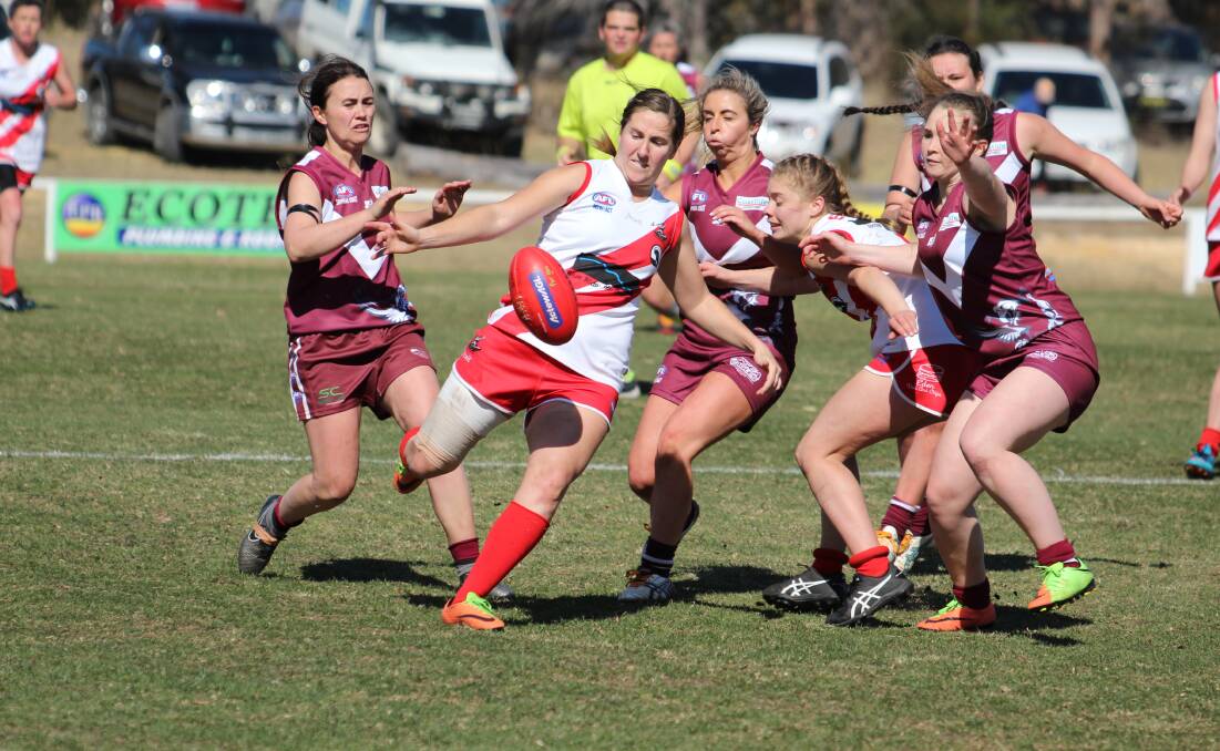 Forward movement: Kamilla Grubesic gets a kick clear of the pack as the Sea Eaglettes close in for a tackle attempt in the grand final on Saturday. 
