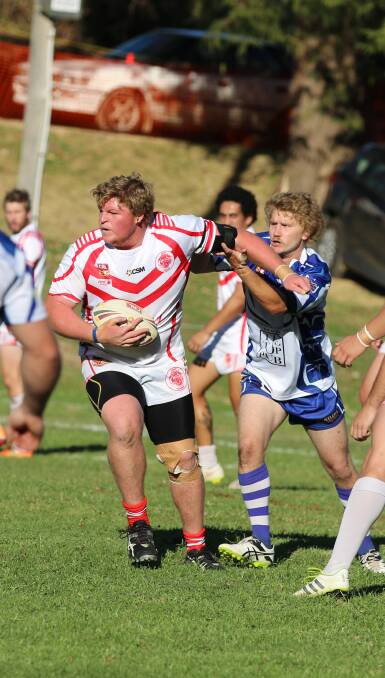 Hard to stop: Eden forward Adam Rodwell fends off a tackle attempt by a Bulldog during Sunday's clash at Candelo. 