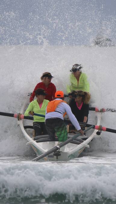Splash: The Pambula open women's surfboat team took to the waters off Pambula Beach for the Club to Pub race on Saturday. Photo: Jacob McMaster