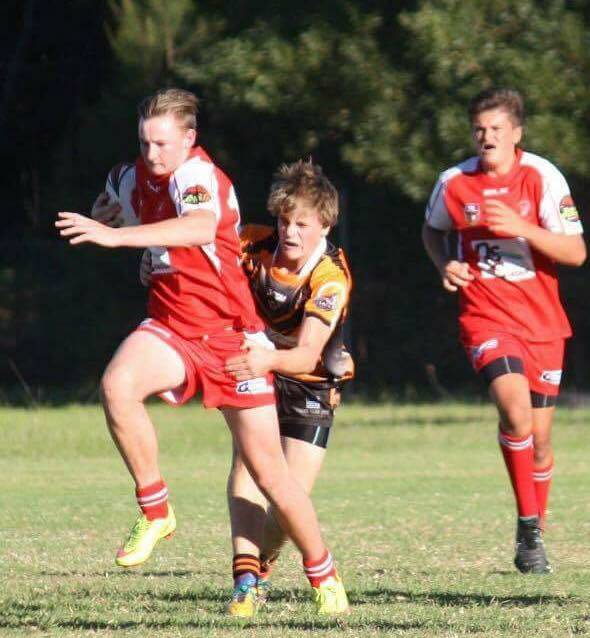 Hard runner: Jordan Martin evades a tackle by a Bay Tiger for the Narooma Devils in a recent match. Picture: Facebook. 