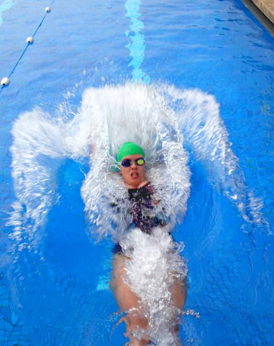 Spray: Claudia Mitchell kicks up some wash during the backstroke heats at the first meet of the Eden Swim Club. Picture: Supplied