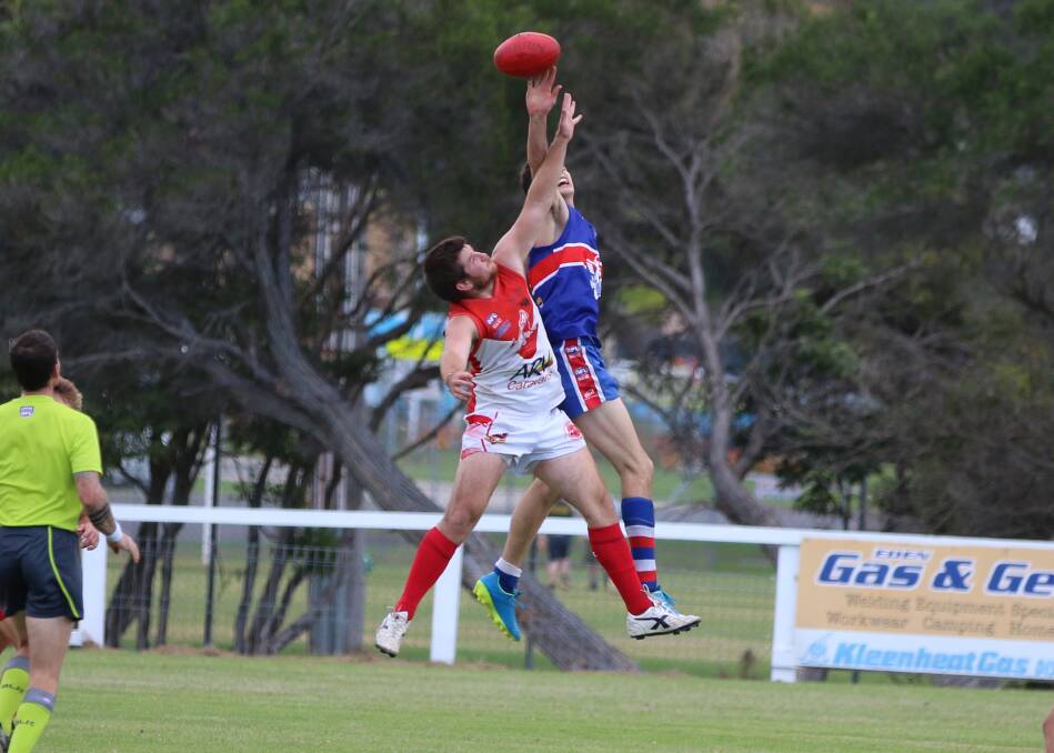 Ball contest: Liam Wilkinson flies high to contest a ball with his Merimbula Diggers counterpart at the Eden ground on Saturday. 
