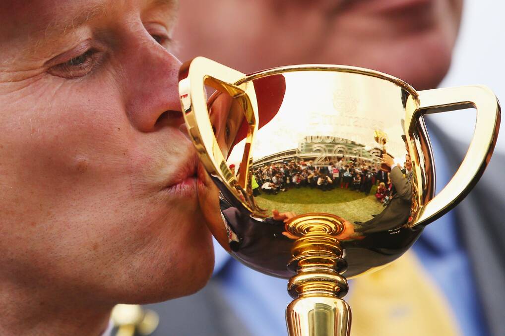 Jockey Kerrin McEvoy celebrates his win on Almandin by kissing the Melbourne Cup on November 1, 2016. The iconic trophy will arrive on the South Coast in July as part of a national tour. Photo: Getty Images