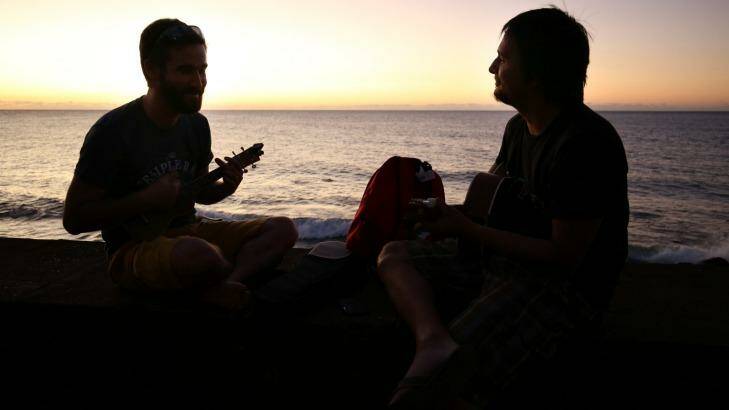Friends Marc Mnemosyne (right) and Ben Vodinh, both originally from Reunion Island and now living in Paris, play the guitar and ukulele on Saint-Denis beach, Reunion Island.  Photo: Colin Cosier