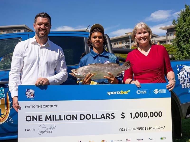 Keegan Payne holds the barramundi that has resulted in him winning $1 million. (Supplied/AAP PHOTOS)