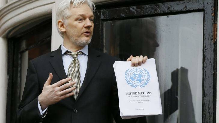 Julian Assange, pictured on the balcony of Ecuador's London embassy, with the UN report that says he is being 'arbitrarily detained' by Britain and Sweden. Photo: Kirsty Wigglesworth