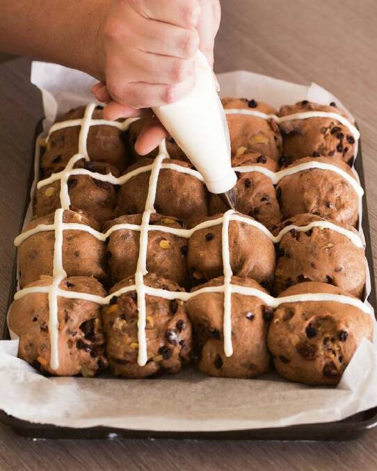 STEP 8: Spoon the flour paste into a piping bag (or small sealable plastic bag). Fit a piping tip to the bag or cut a 3mm hole in one corner. Carefully pipe the crosses over the risen buns. Photo: Tamara West
