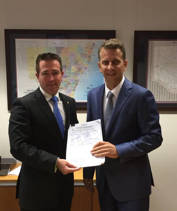 STRONG MESSAGE: Local Government Minister Paul Toole receives from Bega MP Andrew Constance a petition rejecting Eurobodalla Shire Council’s special rate variation, which was approved by IPART last week and accepted by the council on Tuesday. 
