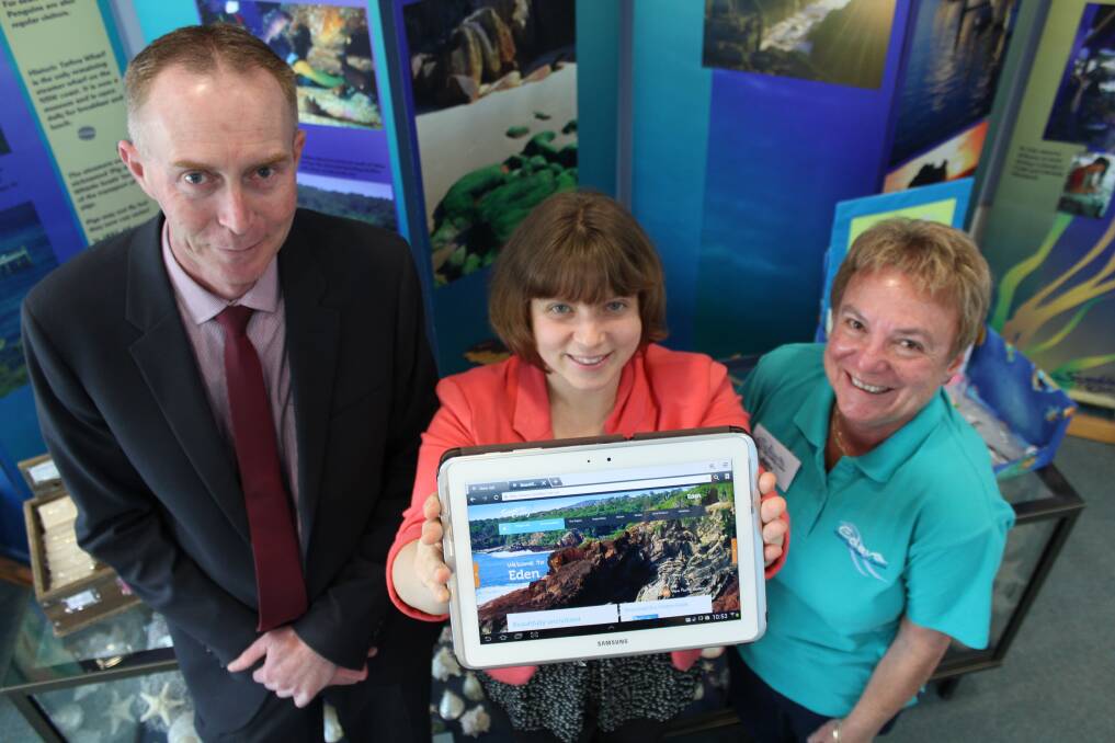 Eden Visitor Information Centre manager Shannon Woloshyn (centre) and volunteer Julie Meade (right) are thrilled with their new iPad, purchased after a grant from the Pambula District & Community Bank, represented by Philip Smith.