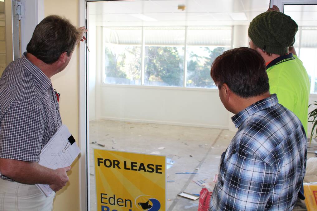 Selling agent Glenn Brunette (left) shows new owner Benjamin Choi and carpentry contractor Kieran Campbell through one of the vacant shops in Twofold Arcade.