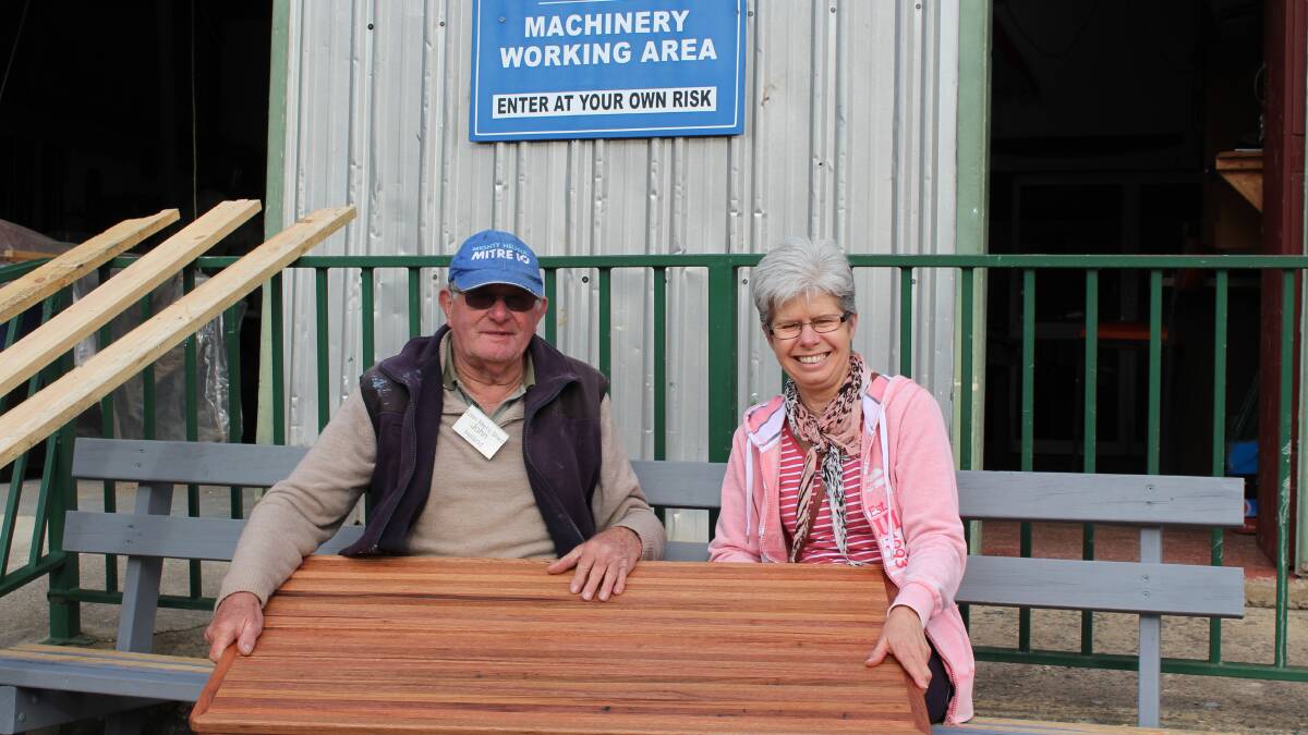 Eden Men’s Shed member John Ireland presents Pam Sykes with the board made from recycled timber, which Pam’s daughter ordered.