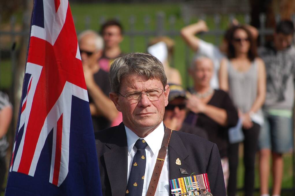 Richard Lamacraft proudly holds the Australian flag at the 11am service at the Eden cenotaph.