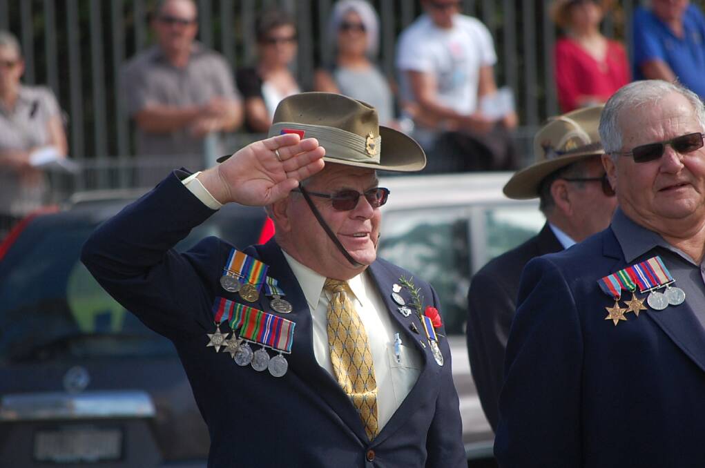 Former Army sergeant Eddy Evans salutes after the Australian national anthem is sung at the 11am service at the Eden cenotaph.
