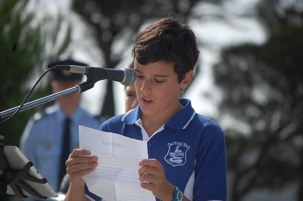 Eden Primary School students reading a poem they wrote to honour our servicemen and women at the ANZAC Day 11am service at the Eden cenotaph.