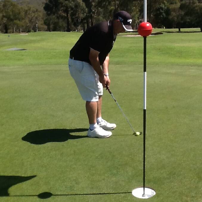 Pambula-Merimbula Golf Club pro Glenn Warne lines up a putt on the oversized holes set up for a family fun day on Monday.