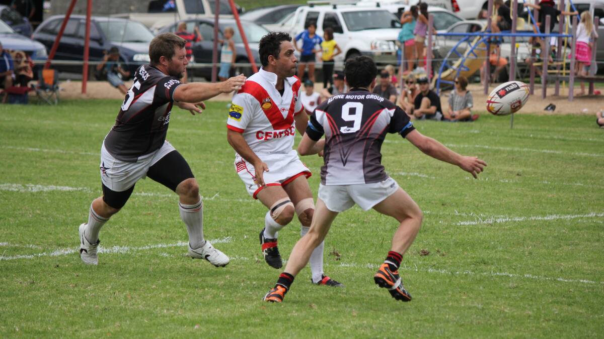• Eden Tigers reserve grade playing-coach Alan Aldridge fires off a pass under pressure from two Cooma Stallions. 