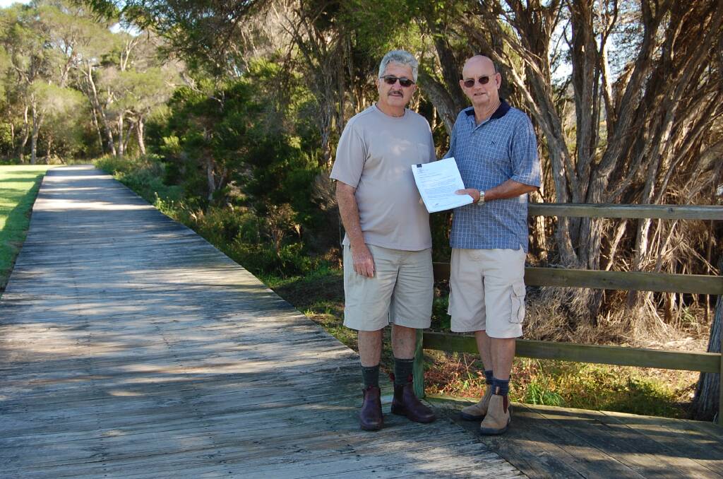 Eden Foreshores Landcare members John Walker and Mike Stebbings with a copy of the petition that attracted 650 signatures. 