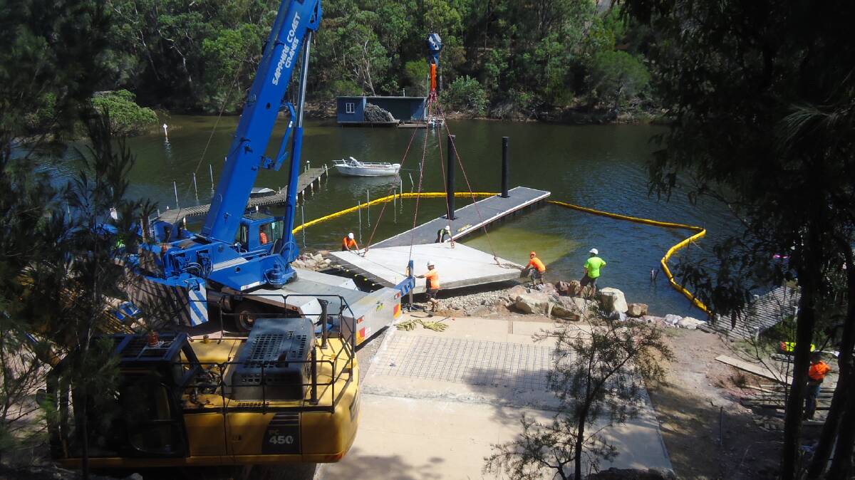 One of two huge pre-cast boat ramp slabs, each weighing 23 tonnes, is lifted into position by crane at Wonboyn Lake. 