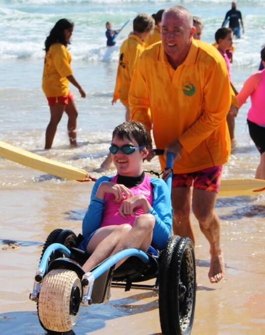 Jake at Pambula Beach in a beach wheelchair.