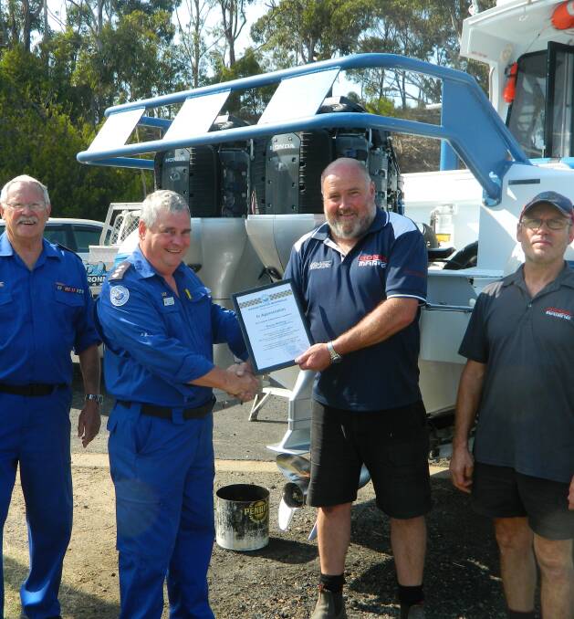 Marine Rescue Merimbula volunteer Ted Young and unit commander Bill Blakeman present a Marine Rescue Certificate of Appreciation to Sapphire Marine and Automotive owner Wayne Holding and employee Rod Patterson.