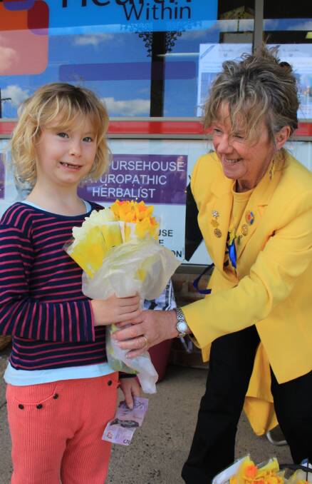 20 years: Robyn Whitby handing some daffodils to five-year-old Mirriam Collins on Daffodil Day.