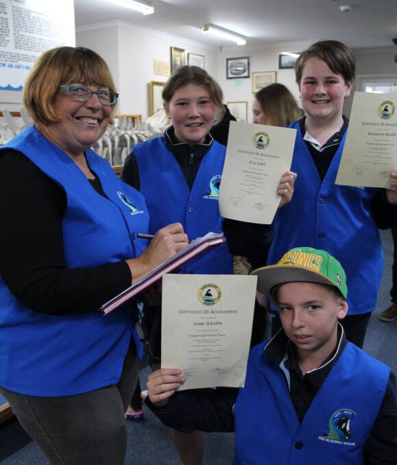 Young volunteers: Eden Killer Whale Museum guide assessor Susie Sarah presents Year 7 Eden High students Eliza O'Dell, Ben Neville and Isaac Gaudie with their Junior Guide certificates. Picture: Melanie Leach