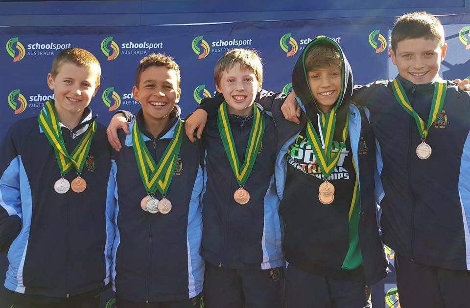 Runner: Eden Year 5 pupil Jack Caldwell (far right) stands with his NSW team with their medals from the School Sport Australia Cross Country Championships. 