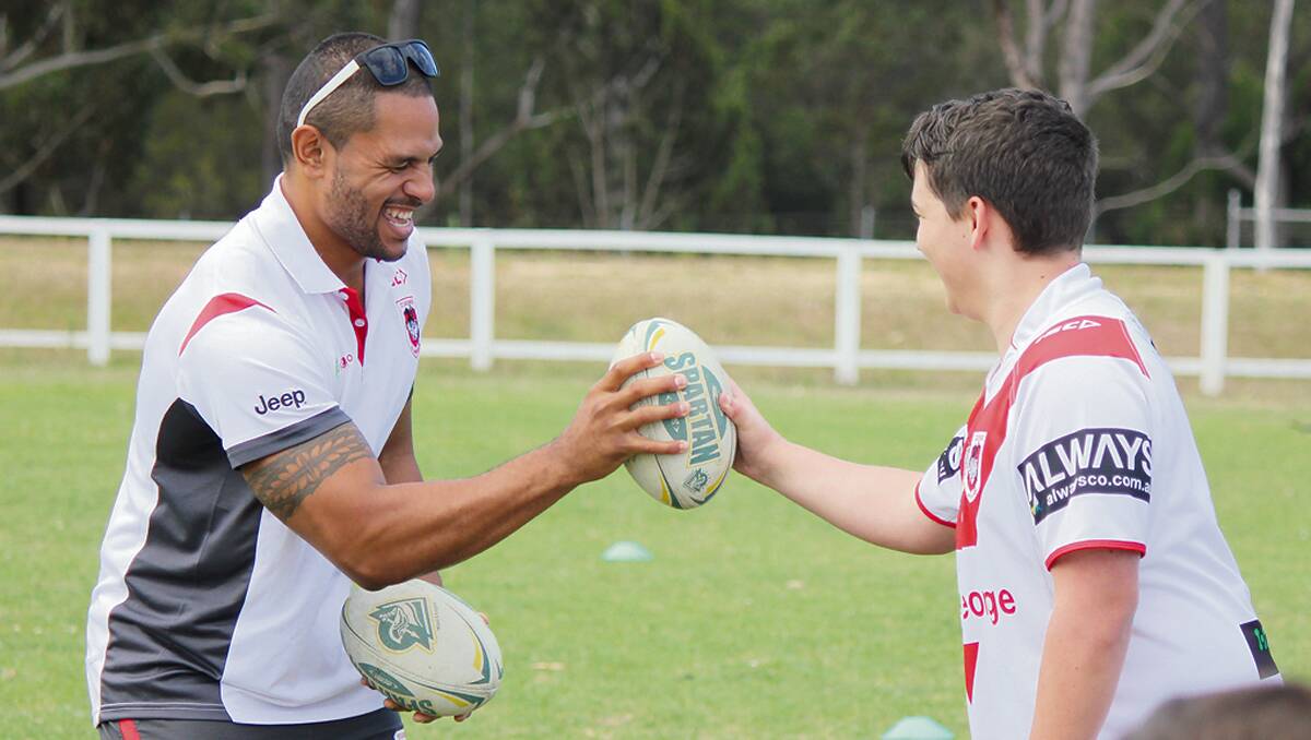 • St George Illawarra Dragon WIllie Mataka tests his grip against a young fan at a training clinic on Tuesday.