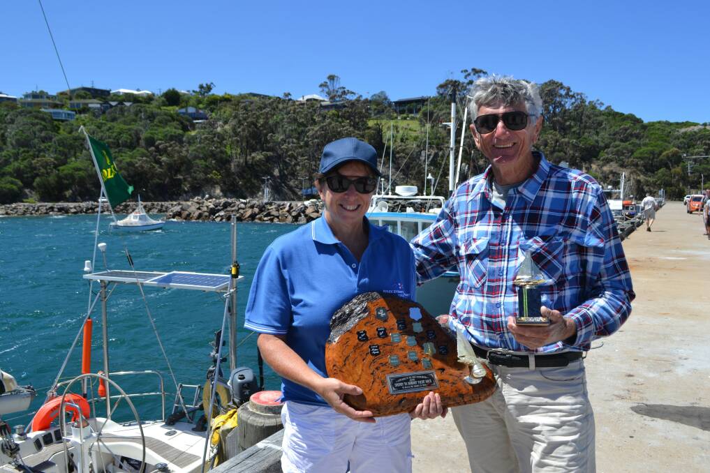 Robyn Malcolm from Twofold Bay Yacht Club and Black Adder owner/skipper Jim Clayton with the 'line honours' trophy for first retiree into Eden.