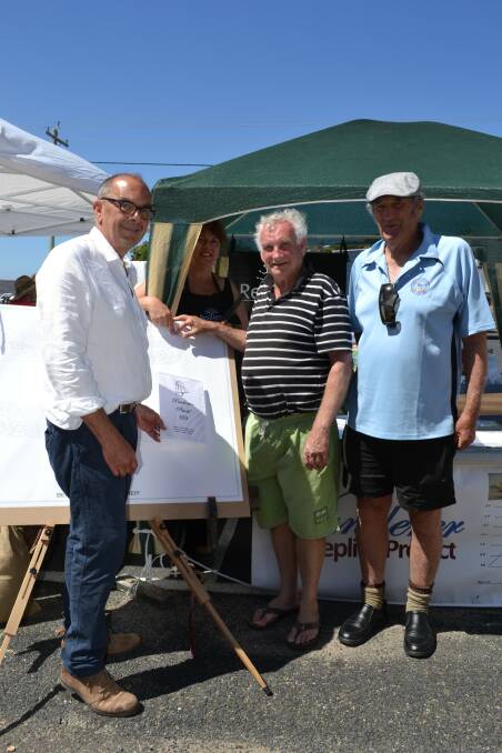 Gordon Beattie (left) bought a plank for the Wanderer project at the Eden Whale Festival. He is pictured with Stephanie McDonald (back) from Resilience and Morrie Lynch (right) from South East Nautical Services 