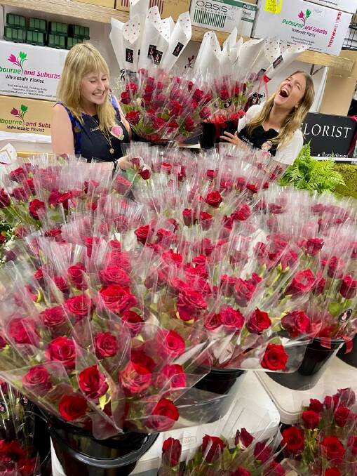 Jasmine Fleet and Marlee Ahmat preparing the single wrapped red roses on Valentine's Day. Picture supplied. 