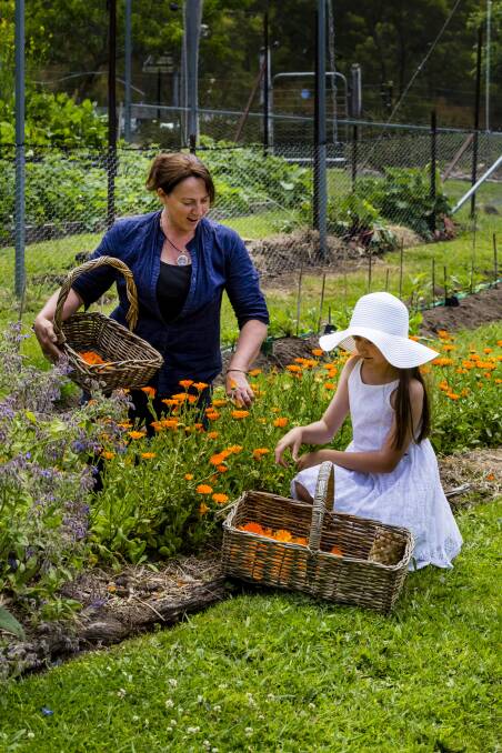 GROWING YOUR OWN: Kay Saarinen cultivating some produce with her daughter, in their permaculture farm at Wyndham. 