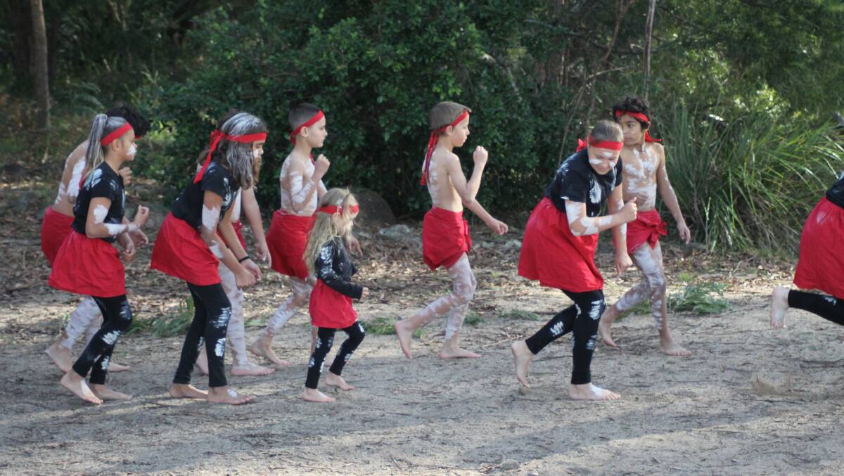 Eden Public School dancers invite little Mia Eve Maher to perform with them for their cultural dances at Jigamy Farm. Photo: Amandine Ahrens