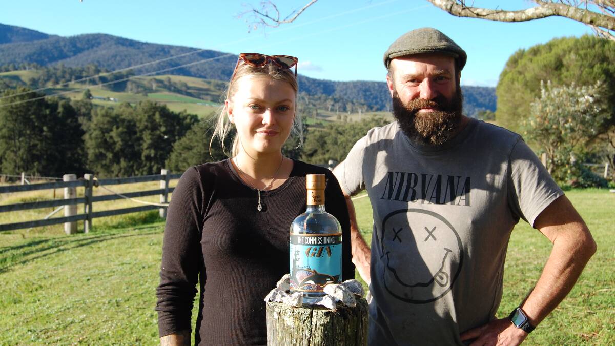 North of Eden's apprentice distiller Ruby Davis with Gavin Hughes, with a bottle of the bespoke Commissioning Gin for crew of HMAS Supply II. Photo: Leah Szanto