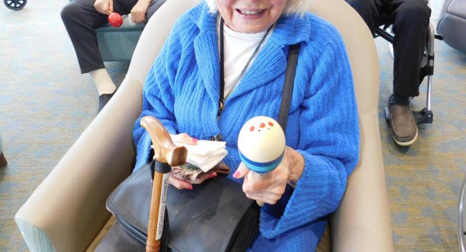 One of the residents uses a maraca to join into the sing-along. Image: supplied. 