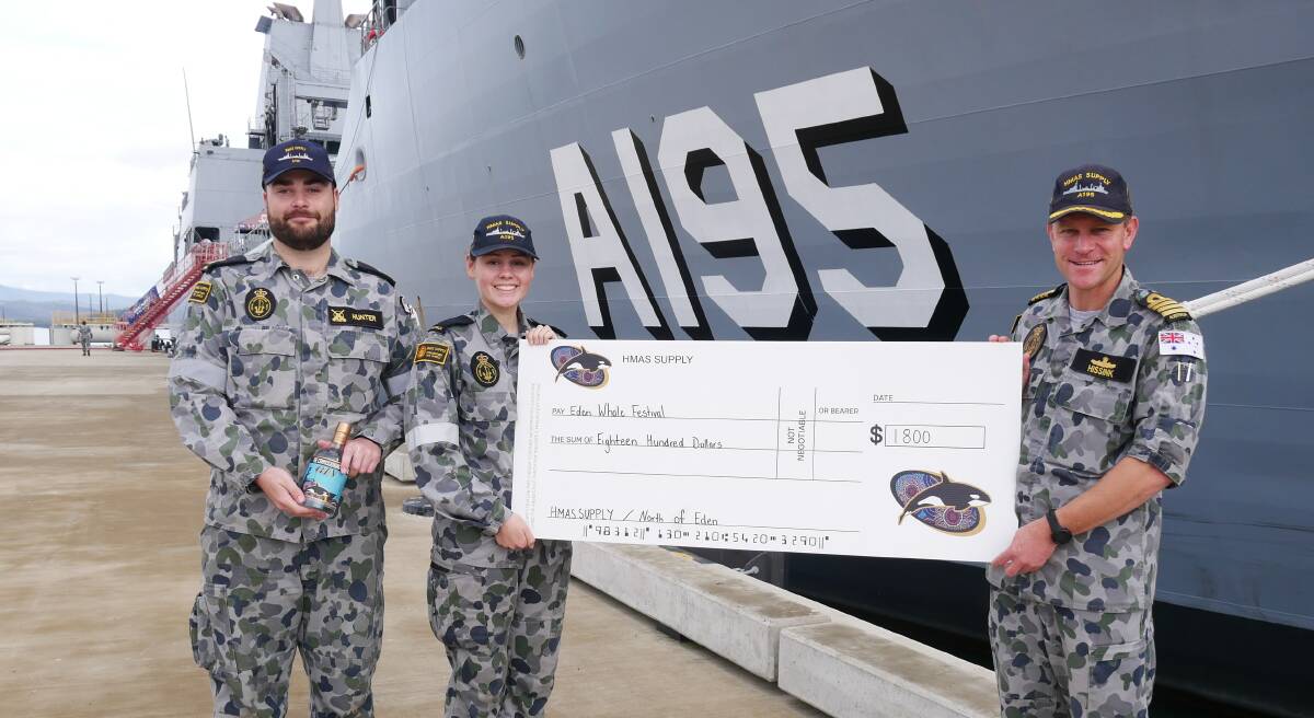 GIVING BACK TO HOME PORT: Mark Hunter hold a bottle of the Commissioning Gin, with Georgie Baldwin and Supply II Captain Ben Hissink holding a cheque for $1800 to go towards the Eden Whale Festival. Photo: Ellouise Bailey 