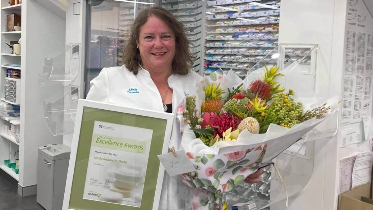 Linda Badewitz-Dodd with the award and flowers Merimbula's Dodd and Dwyer Amcal Pharmacy. Photo: Tania Dwyer 