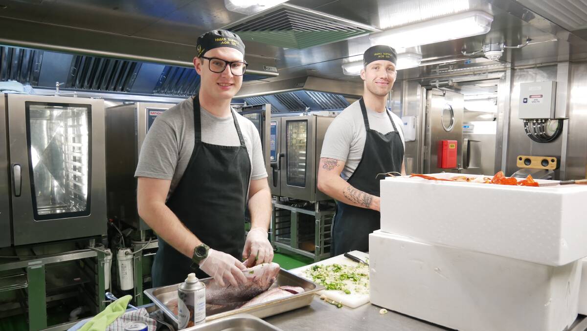 Chefs and able seamen Tim Eason and Hugo Pfiffer in the ship's galley preparing meals for some of the 174 crew members. Photo: Ellouise Bailey