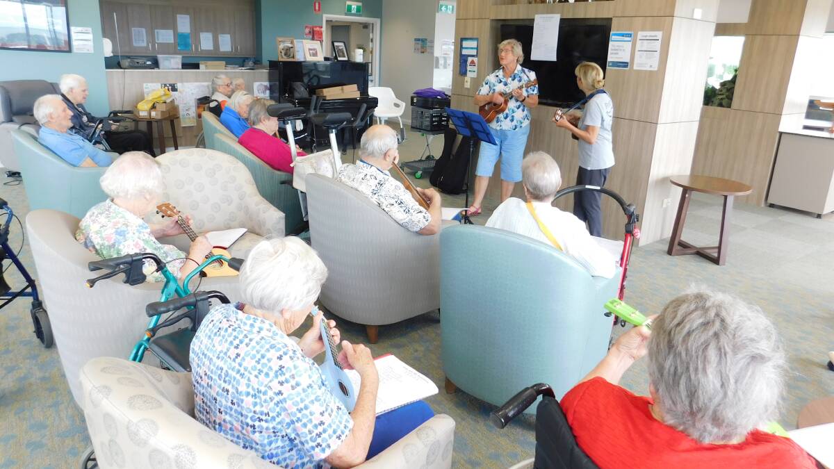 Woobles volunteers Adeline Perrett and Barbara Allgaier conducting one of their monthly practice sessions with about 15 residents eager to learn how to play the ukelele at Albert Moore Gardens in Merimbula. 